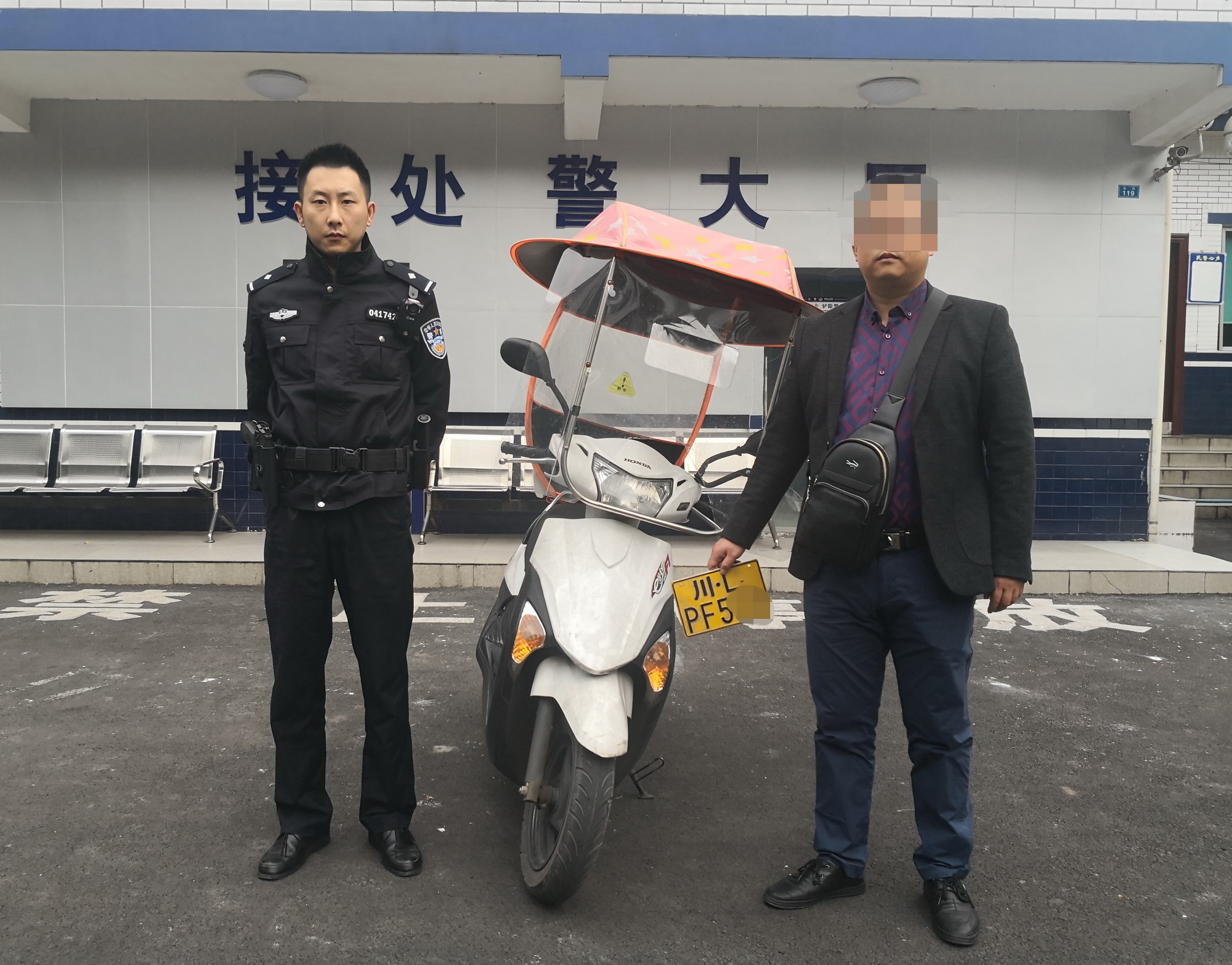 图为失主张先生领回摩托车后与民警合影留念.jpg