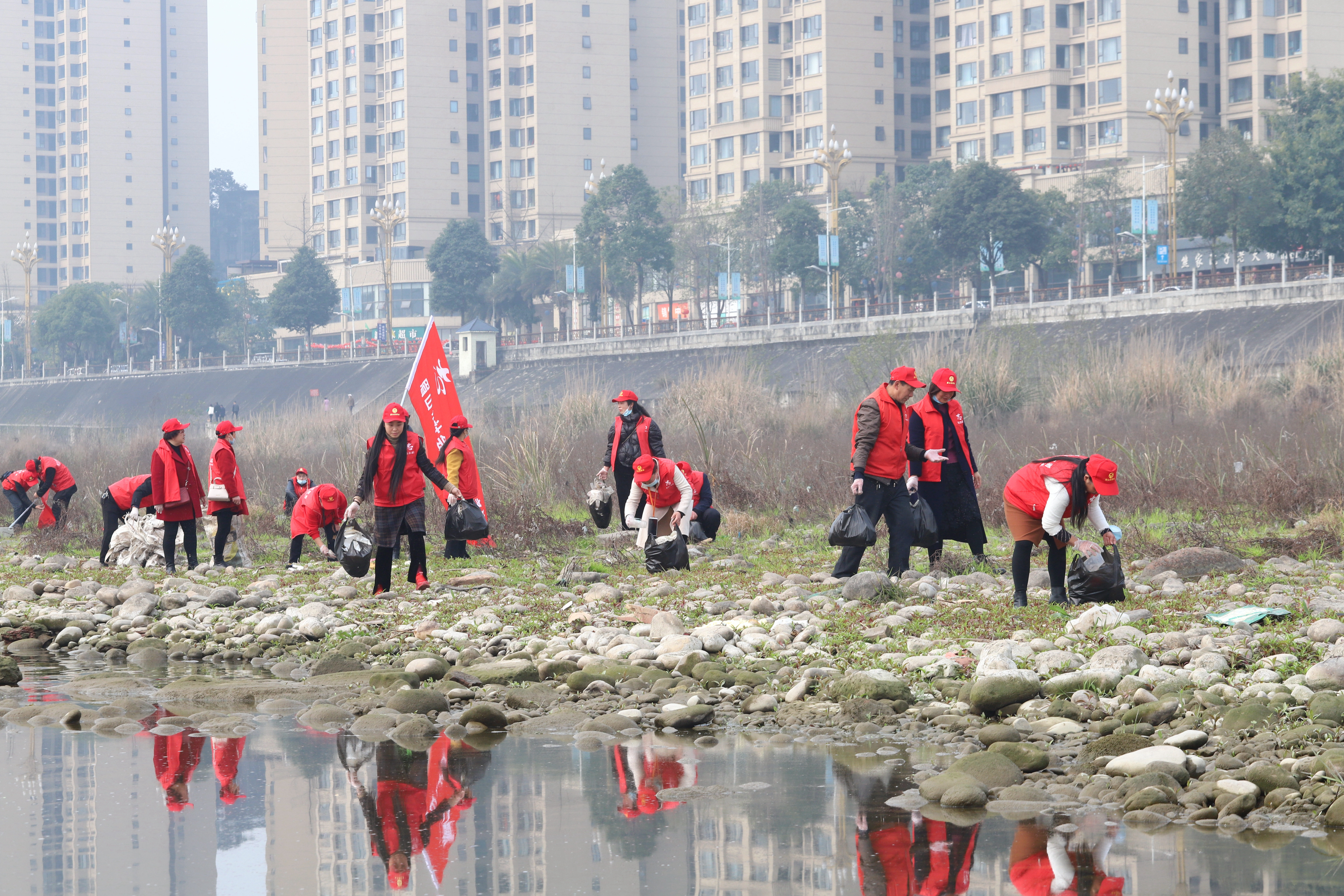 1.志愿者在河边捡垃圾。.JPG